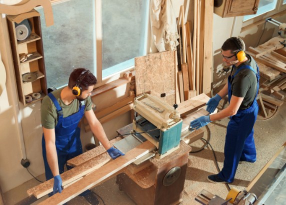 Equipo de carpinteros cepillando madera en el taller propio de la C. Lanuza, Málaga