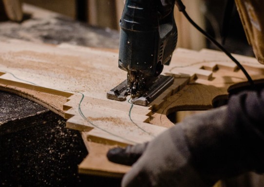 Corte de un tablero de madera para las baldas de una librería a medida en el taller