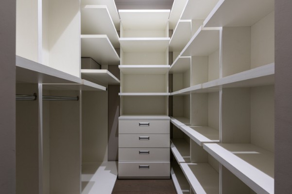 Librería a medida de suelo a techo con estantes regulables y cajonera central