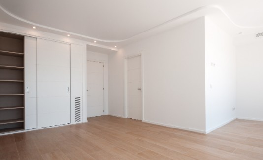Dormitorio reformado en Málaga con armario empotrado corredero, puerta de paso lacada y suelo de madera nuevos